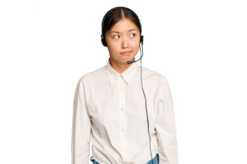 Telemarketer asian woman working with a headset isolated on green chroma background confused, feels doubtful and unsure.