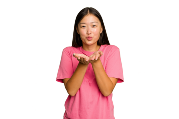 Young Asian woman isolated on green chroma background folding lips and holding palms to send air kiss.