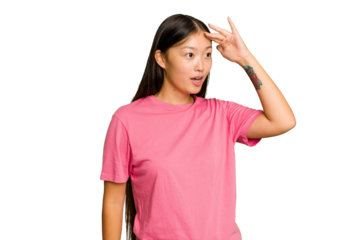 Young Asian woman isolated on green chroma background looking far away keeping hand on forehead.