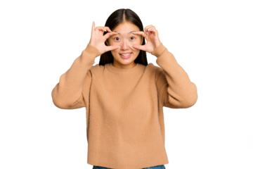 Young Asian woman isolated on green chroma background keeping eyes opened to find a success opportunity.