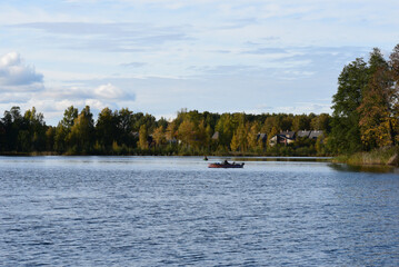 beautiful view of the lake with fishing boats on a sunny autumn evening