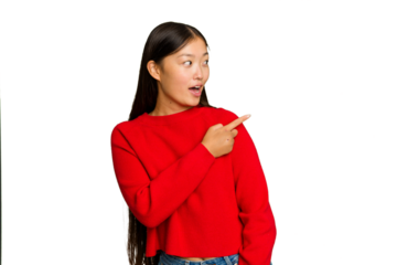 Young Asian woman isolated on green chroma background points with thumb finger away, laughing and carefree.