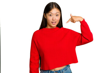 Young Asian woman isolated on green chroma background person pointing by hand to a shirt copy space, proud and confident