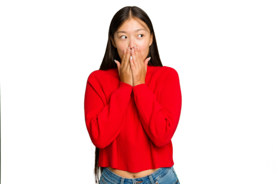 Young Asian woman isolated on green chroma background thoughtful looking to a copy space covering mouth with hand.