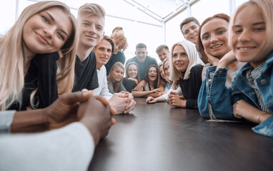 close up. a large group of friends sitting at a long table