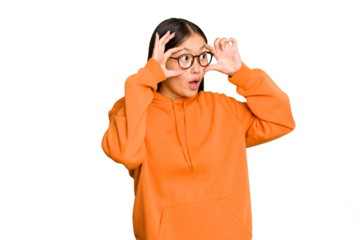 Young Asian woman isolated on green chroma background keeping eyes opened to find a success opportunity.