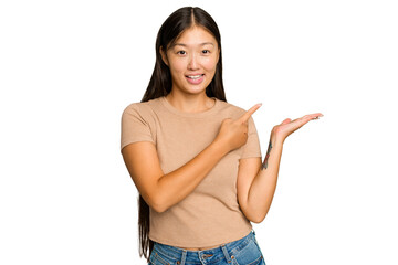 Young Asian woman isolated on green chroma background excited holding a copy space on palm.