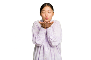 Young Asian woman isolated on green chroma background folding lips and holding palms to send air kiss.