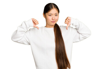 Young Asian woman isolated on green chroma background showing thumb down, disappointment concept.