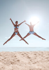 Obraz premium Picture of happy couple jumping on the beach.