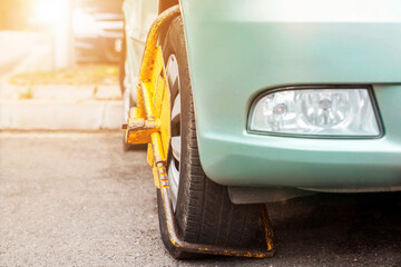 Car Wheel Blocked by Wheel Lock because illegal parking violation. Clamped front Wheel in...