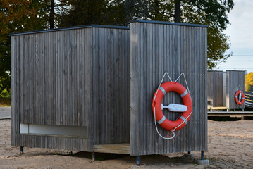 a changing cabin with an attached orange lifebuoy in the macaw park on the beach