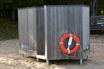 a changing cabin with an attached orange lifebuoy in the macaw park on the beach
