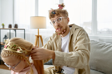 Father with crazy hairstyle making hair for daughter