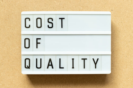 Lightbox with word cost of quality on wood background
