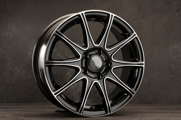 beautiful black alloy wheel new on a gray background.