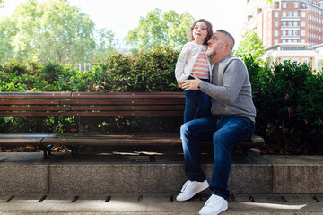Fototapeta premium Father and his daughter sitting on a bench.