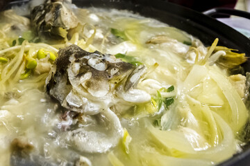 Head fish cooking in a broth of vegetables, restaurant in Gunsan, South Korea