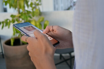 Selective focus of woman's hands checking the news from her smart phone outdoors