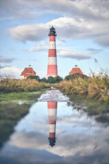 Reflection of Lighthouse Westerheversand. High quality photo