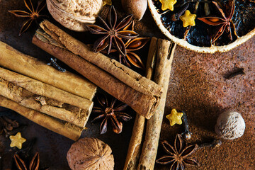 Christmas spices. Christmas composition with cinnamon sticks; anise stars, nutmeg, cloves, hazelnut and dried orange slices on dark background.