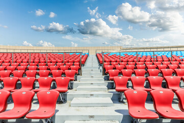 Red seats and beautiful sky clouds in the stadium