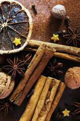 Christmas spices. Christmas composition with cinnamon sticks; anise stars, nutmeg, cloves, hazelnut and dried orange slices on dark background.