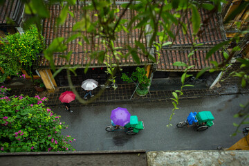 Tourists walking in Hoi An when it rains
