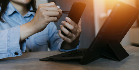 Businessman hands working with finances about cost and calculator and laptop with tablet, smartphone at office in morning light