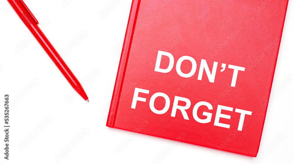 Aufkleber the text do not forget is written on a red notepad near a red pen on a white table in the office. bu