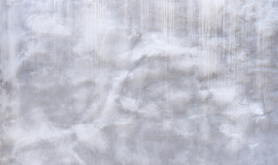 Detail einer verputzten Wand mit abstraktem weiß grauen Muster und leichten Rissen