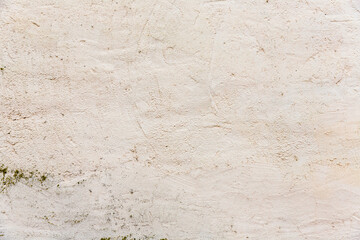 Weiße verputzte Wand mit Moos und Verunreinigungen als Hintergrund