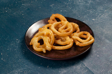 indian sweets deep fired jalebi, jilipi, jilabi served in a dish isolated on background top view