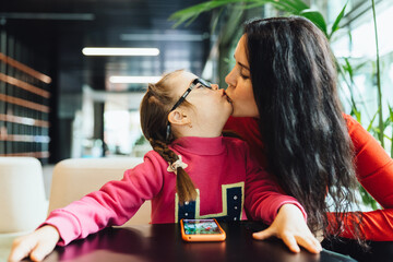 Happy family moments concept.Mother and cute little daughter in lobby or cafe.