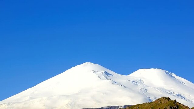 Snow-covered top of Elbrus on a background of the blue