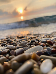 View of the sea and sun rising above the stones in Cirali, Antalya, Turkey. Selective focus.