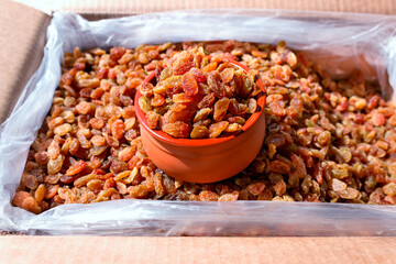 Bright raisins in a ceramic bowl. The concept is raw food, vegetarianism, healthy eating. Selective focus.
