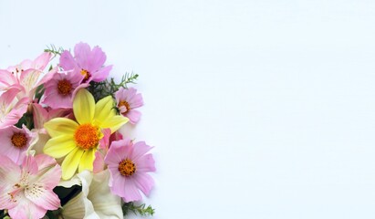 Pink and yellow flowers in a festive bouquet on a white background. Summer flower arrangement. Background for a greeting card.