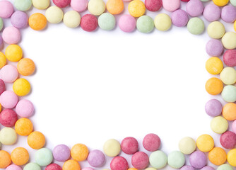 Frame of colorful candies over white background with copy space