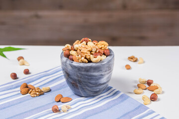 Marble bowl filled with shelled almonds, walnuts, cashew nuts