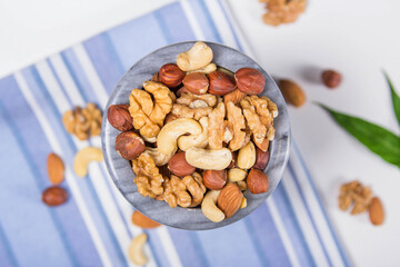 Marble bowl filled with shelled almonds, walnuts, cashew nuts