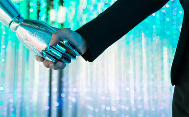 Businesswoman and robot hands in handshake
