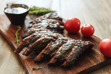 BBQ grilled pork ribs in Barbecue sauce on vintage wooden table background. Barbecue Pork Spare Ribs. Tasty snack to beer. American food concept. Selective focus - 535281623