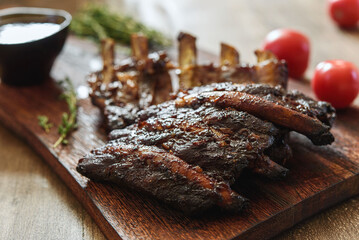 BBQ grilled pork ribs in Barbecue sauce on vintage wooden table background. Barbecue Pork Spare Ribs. Tasty snack to beer. American food concept. Selective focus - 535281624