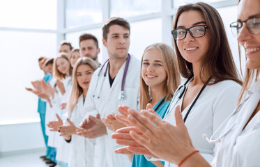 top view. a group of smiling doctors pointing at you.