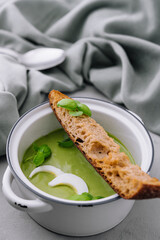 Plate of broccoli and green peas cream soup with bread toast