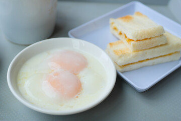 half boiled egg, toasted bread and tea on table 