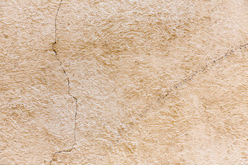 Wand oder Mauer  beige verputz mit Rissen als Hintergrund