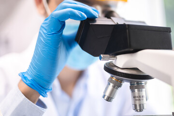 professional research scientist concentration using microscope in chemistry medicine laboratory,...