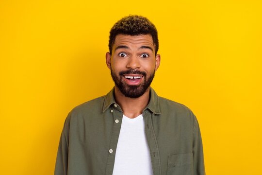 Photo of funky impressed man wear khaki shirt big eyes open mouth isolated yellow color background